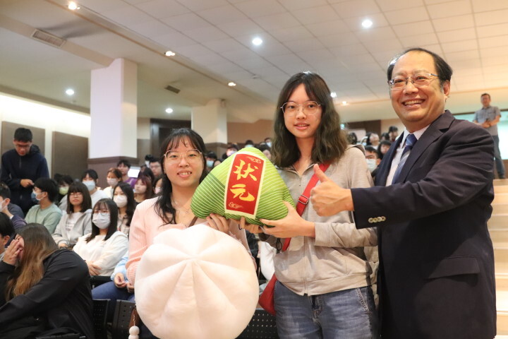 孫逸民校長把大包子和大粽子交由學生傳遞,期盼華醫學子個個國考「包中」過關