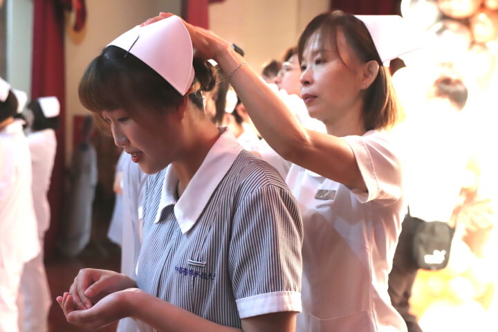 中華醫大護理系114年加冠典禮，加冠學生接受老師配戴護理師帽