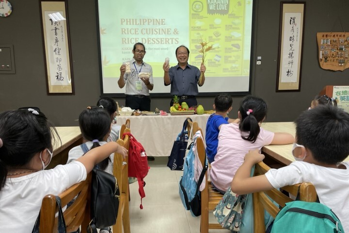 中華醫大校長孫逸民(右)與菲律賓英語老師Gracia 展示台菲米食點心與特色水果